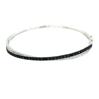 This diamond-studded 14k white gold bangle bracelet has double rows of "X" shapes, totaling 1 carat.