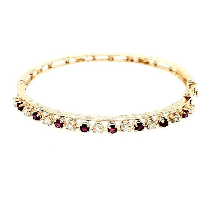 Beautiful and unique 14K yellow gold filigree bangle with 8 round rubies totaling 0.78 ctw.