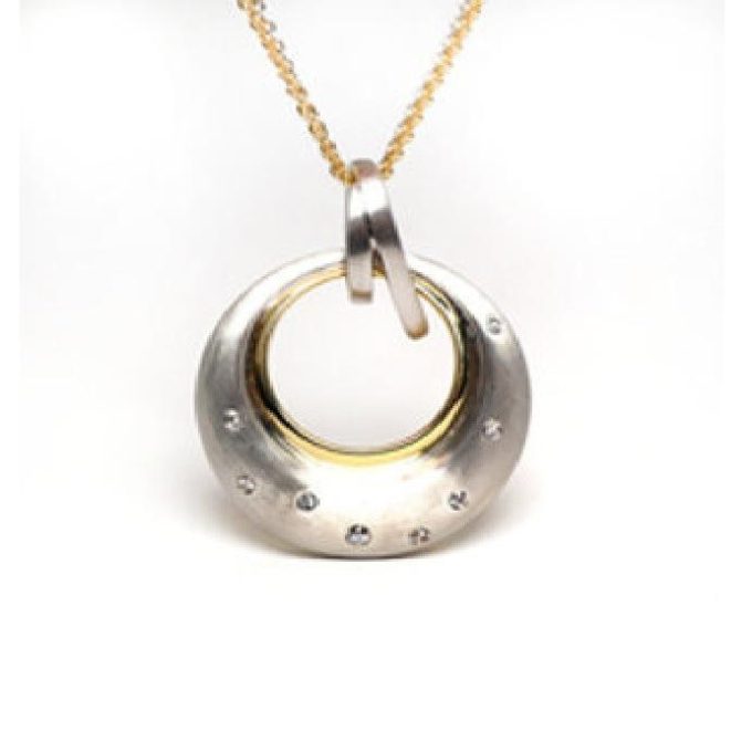 This elegant pendant features a radiant white sapphire intricately set in a round satin sterling silver frame with yellow gold plating. The opulent adornment comes with an adjustable wheat chain, allowing customization to suit any neckline or outfit, ensuring a perfect, subtle touch of sparkling luxury to elevate your everyday attire.