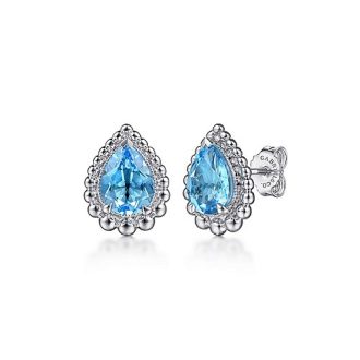Fashion-forward earrings featuring pear-shaped Swiss blue stones with bujukan studs for a luxurious look.