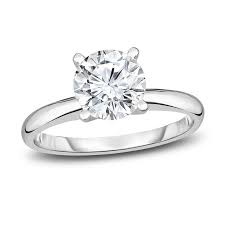 This resplendent engagement ring, forged from 14 karat white gold, showcases a captivating center with 0.70 carat weight. Decoratively framed by radiant solitaire round stones, this iconic treasure is perfected to celebrate your unique love story - a precious toast of brilliance set in luxurious white gold. Adorn your loved one with this stunning symbol of unity.